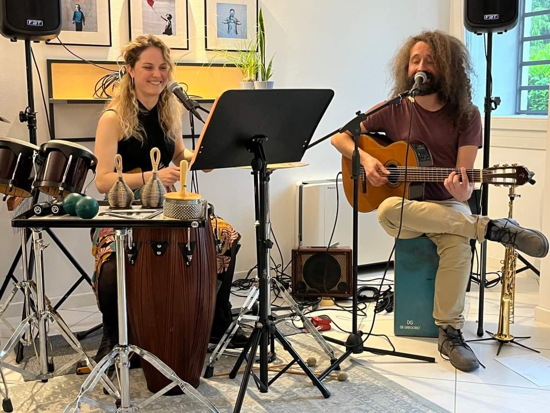 Afro Samba Duo singing and playing guitar at a house concert