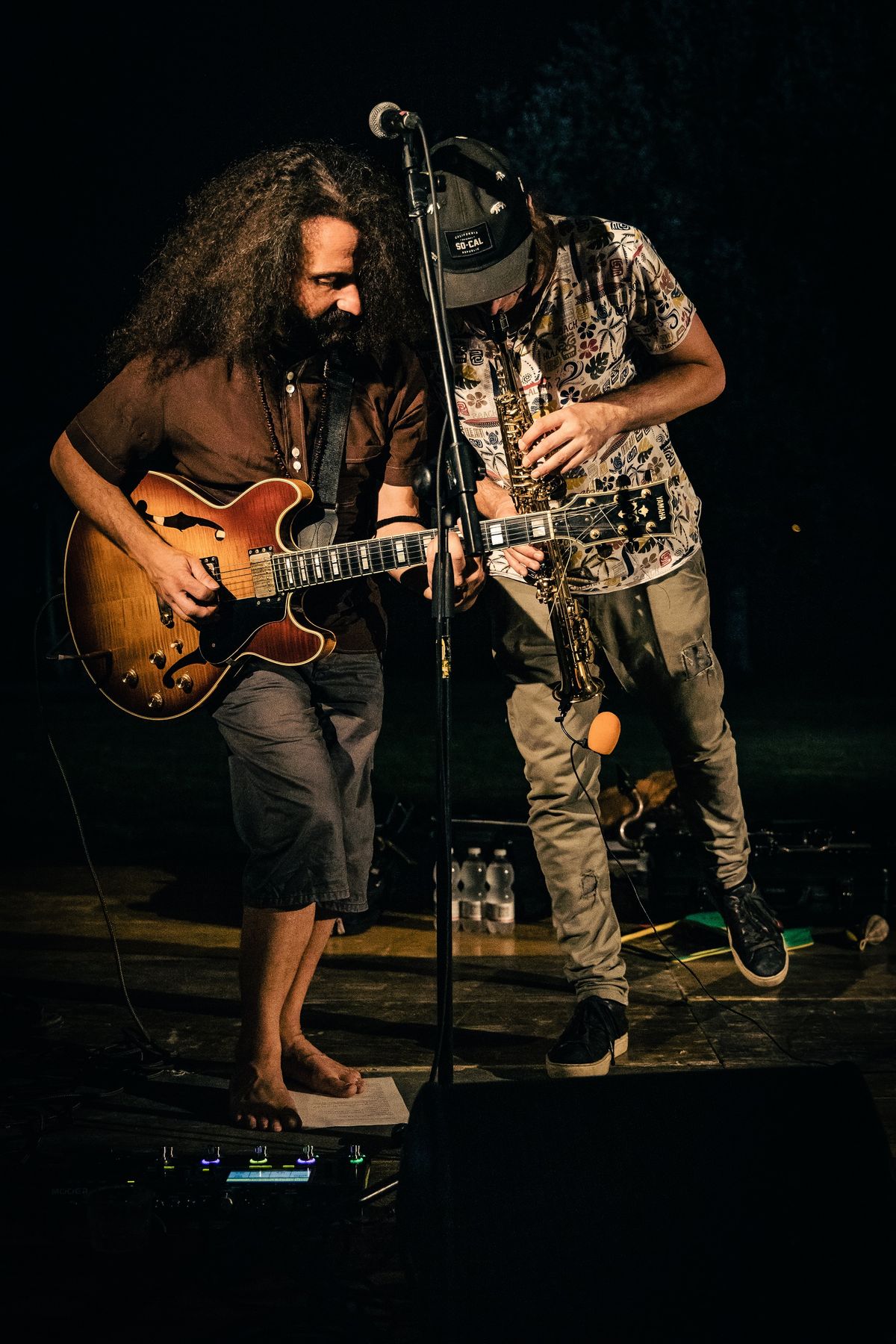 Two musicians performing with guitar and wind instrument