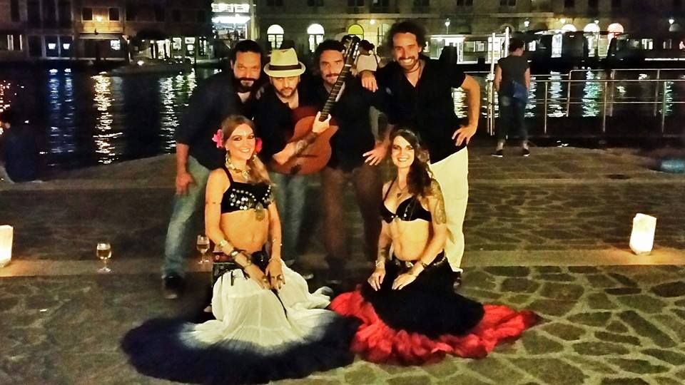 Musicians and dancers beside a canal at night