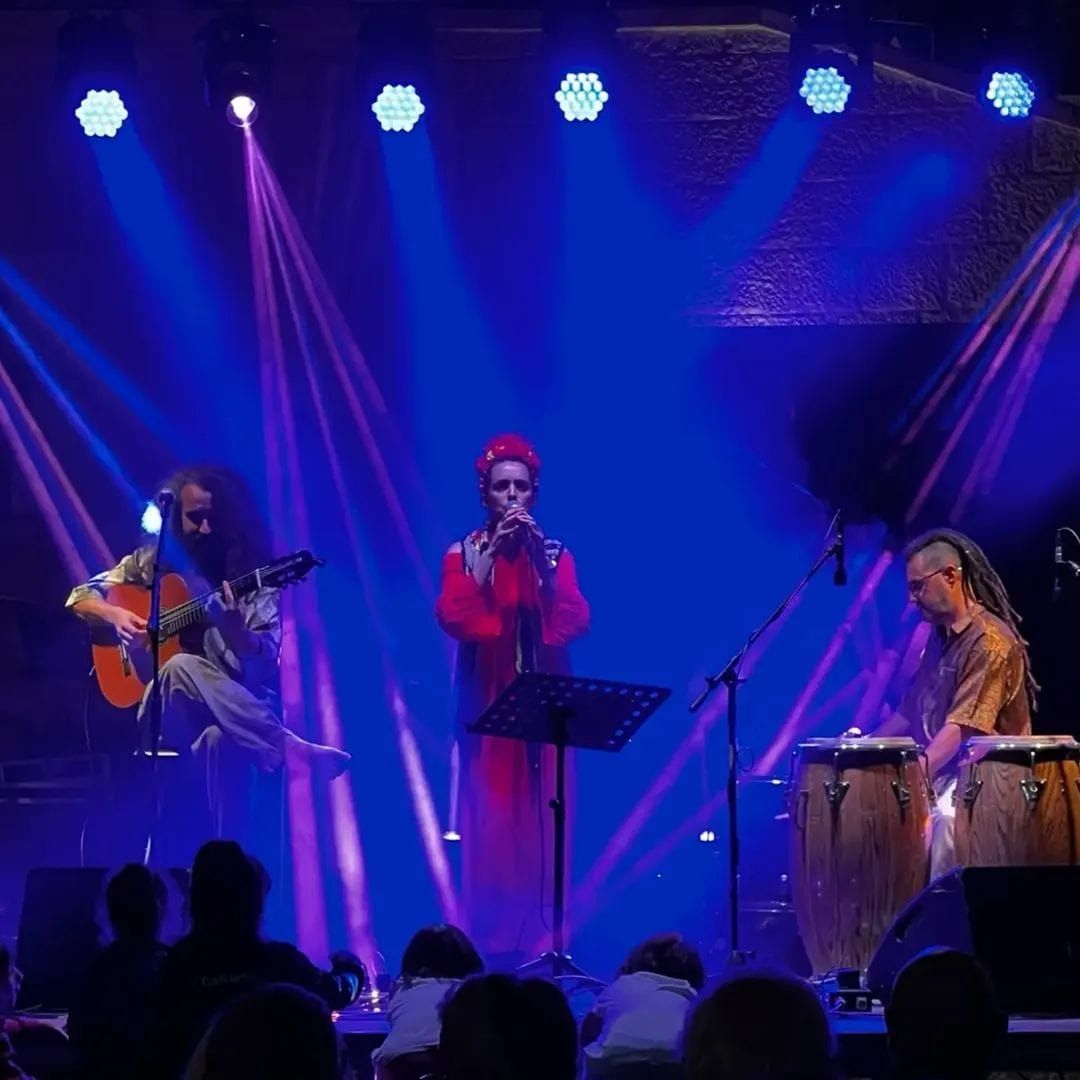 Musicians performing under blue stage lights