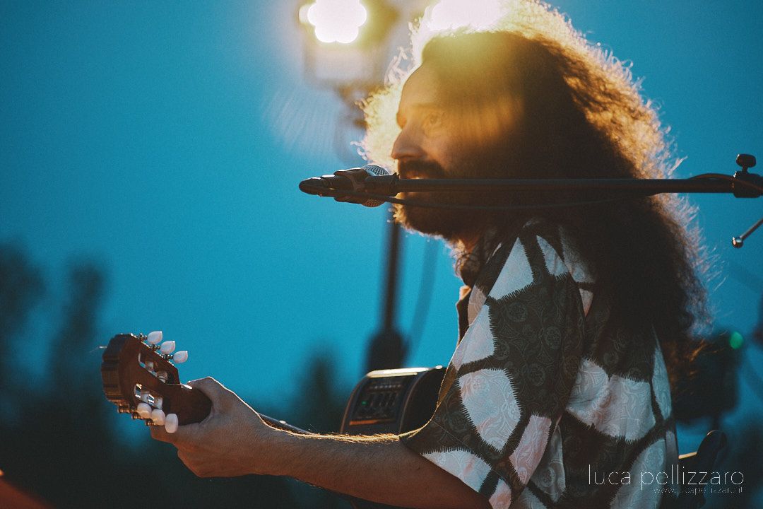 Giulio Gavardi playing guitar on stage.