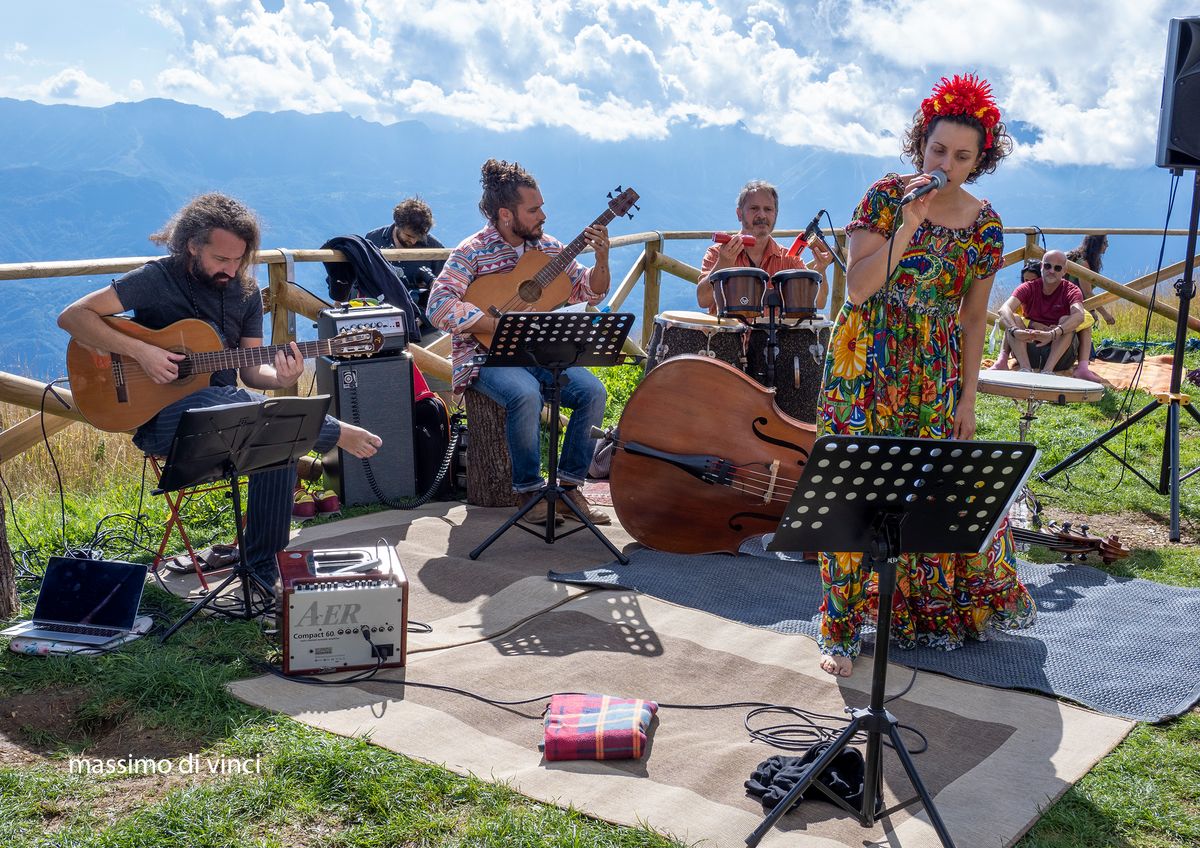 Singin' Woods performing outdoors with mountains behind the stage